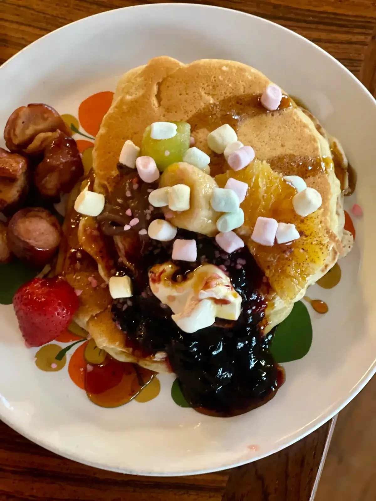 Amerikansk pannekake med syltetøy, krem, marshmallows og stekt pølse på retrotallerken